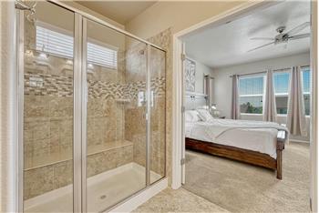 Enclosed tiled shower with built-in seat in the Primary Bathroom.