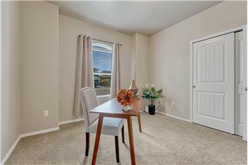 Main Level Bedroom #2 (currently an office) with neutral carpet, front yard views, and a generous closet.
