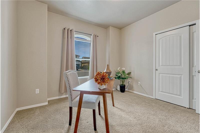 Main Level Bedroom #2 (currently an office) with neutral carpet, front yard views, and a generous closet.