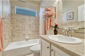 Main Level Full Bathroom with vanity, mirror, and tiled tub/shower.