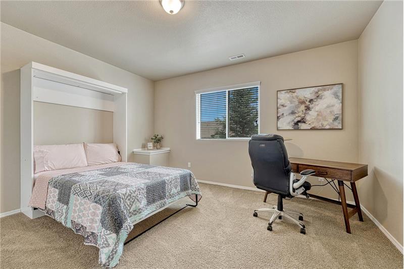 Basement Bedroom #5 has neutral carpet and space for a desk area.