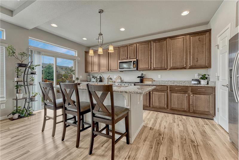 The Island Kitchen offers a breakfast bar with pendant lights and slider to the backyard.