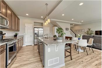 Island Kitchen with pendant lights, a breakfast bar, pantry, and wood cabinets with granite countertops.