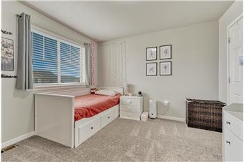 Upper Level Bedroom #1 with neutral carpet and a large view window with blinds and window treatments.