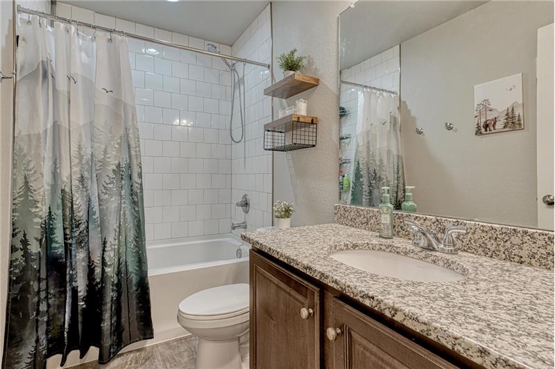 Upper Level Hall Bathroom with vanity, mirror, and tiled tub/shower.