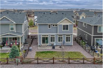 Fenced, level backyard and rear view of home.