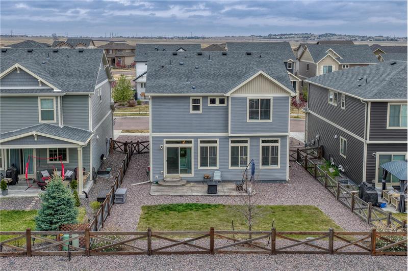 Fenced, level backyard and rear view of home.
