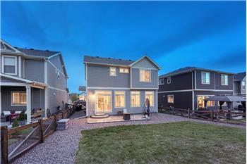 Sunset rear view of home, backyard, and patio.