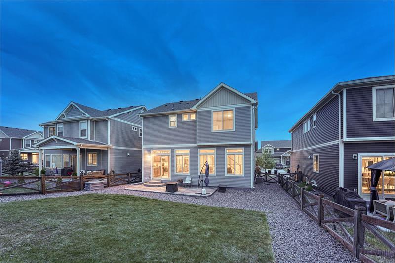 Sunset rear view of home and backyard.