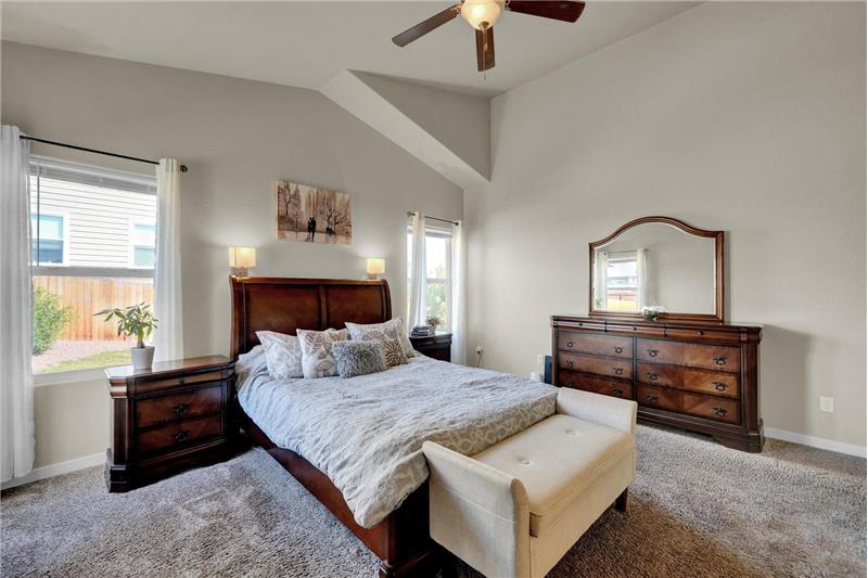 The vaulted Master Bedroom has a lighted ceiling fan and carpet