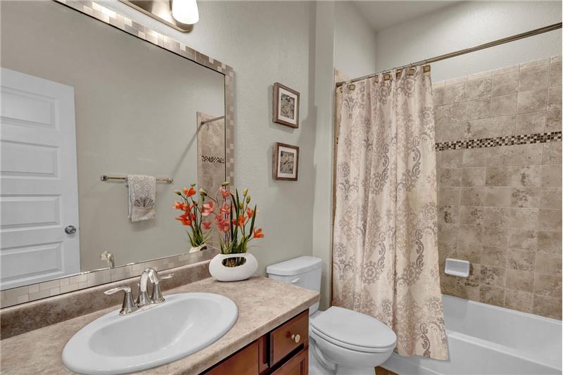 Full Hall Bathroom with tile floors, a vanity, and a tiled tub/shower