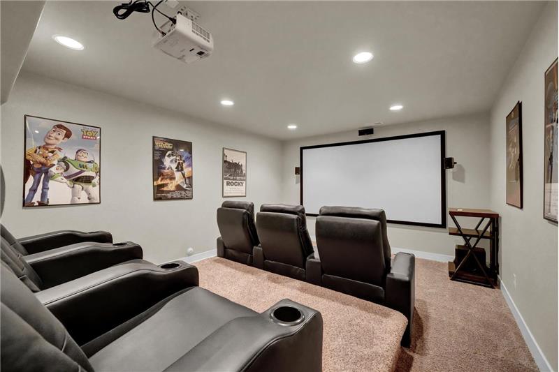The Theatre Rm is wired for surround sound, has an HDMI for the projector, boasts neutral carpet, a projector screen, & seating