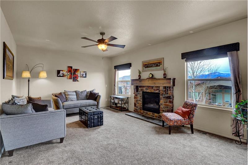 The main level Family Room has a gas log fireplace with a stone surround, & beautiful Peak views