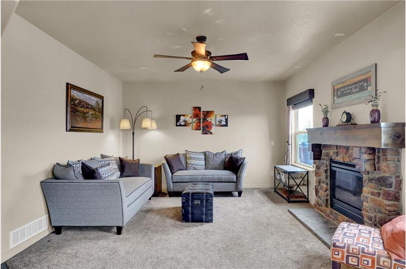 The main level Family Room features neutral carpet, a lighted ceiling fan, and is wired for speakers