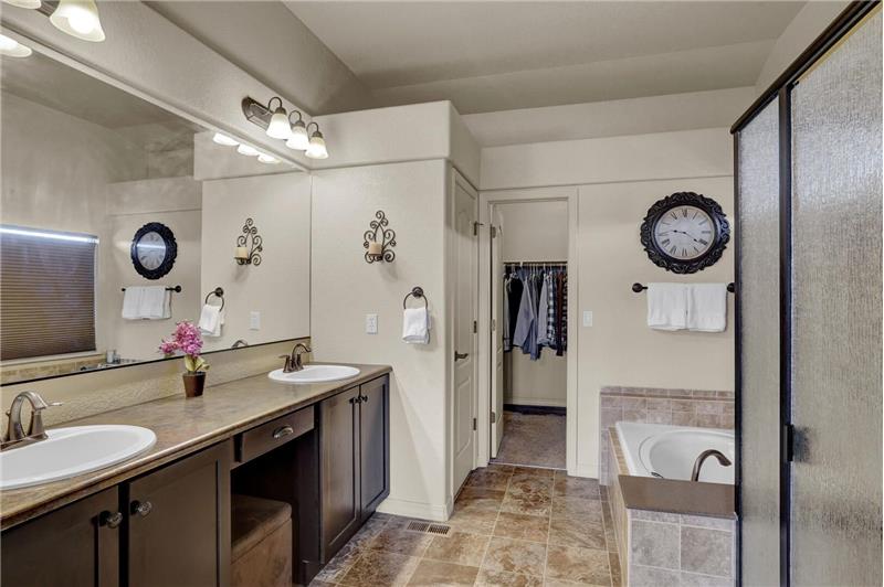 The Master Bathroom features tile flooring, a raised, dual sink vanity, tiled tub/shower, and a walk-in closet with cedar lining