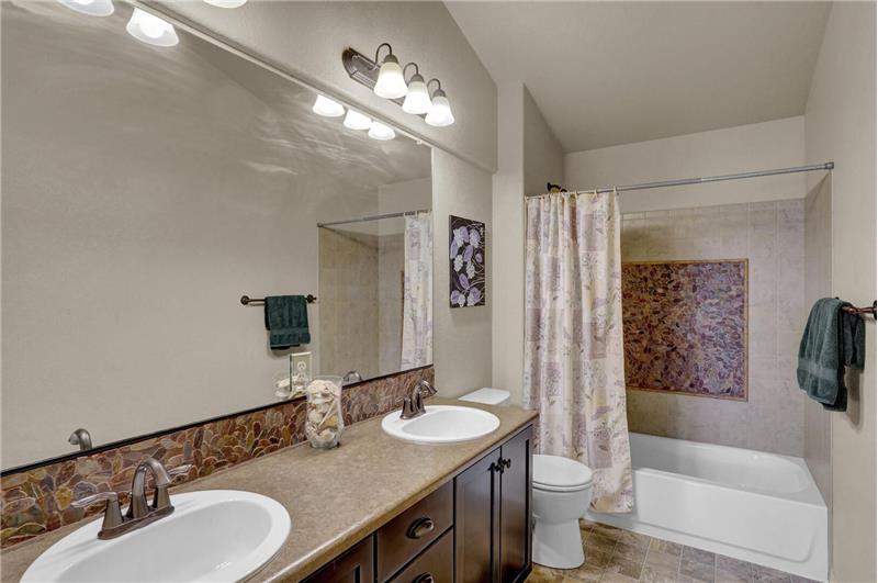 The upper-level Hall Bathroom features a vinyl floor, dual sink vanity, and tiled tub/shower