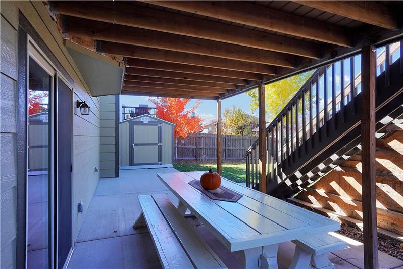 The lower-level covered patio located outside the Basement Rec Room has a picnic table for outdoor dining and fun 