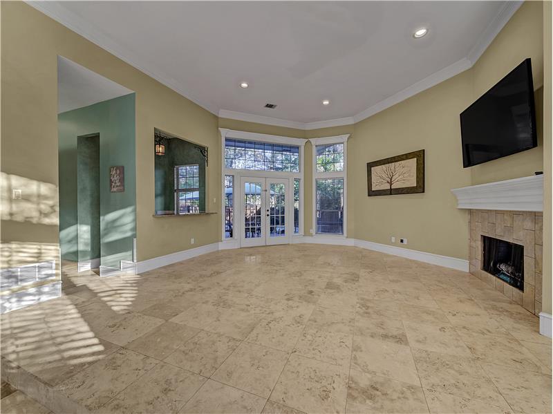 Front living room with crown molding, wet bar, a gas fireplace and french doors leading to the backyard pool and spa!