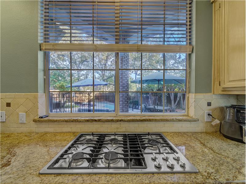 Stainless steel Gas cooktop overlooking the backyard Oasis!