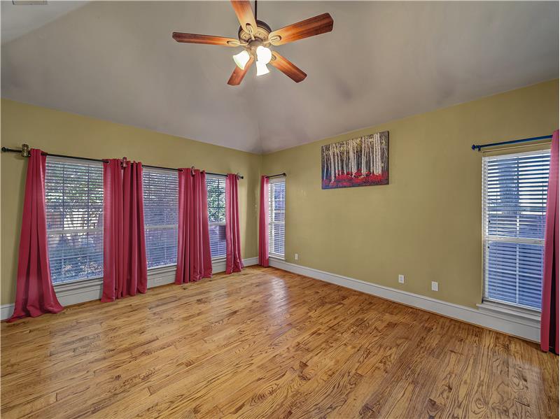 Primary Bedroom featuring light wood flooring, lots of windows and high ceilings!