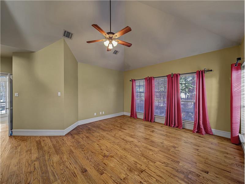 Primary Bedroom featuring light wood flooring, lots of windows and high ceilings!