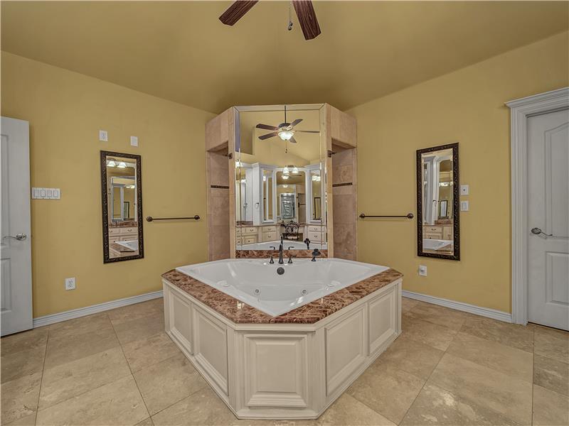 Bathroom featuring tile patterned flooring, a bathtub, lofted ceiling, and ceiling fan