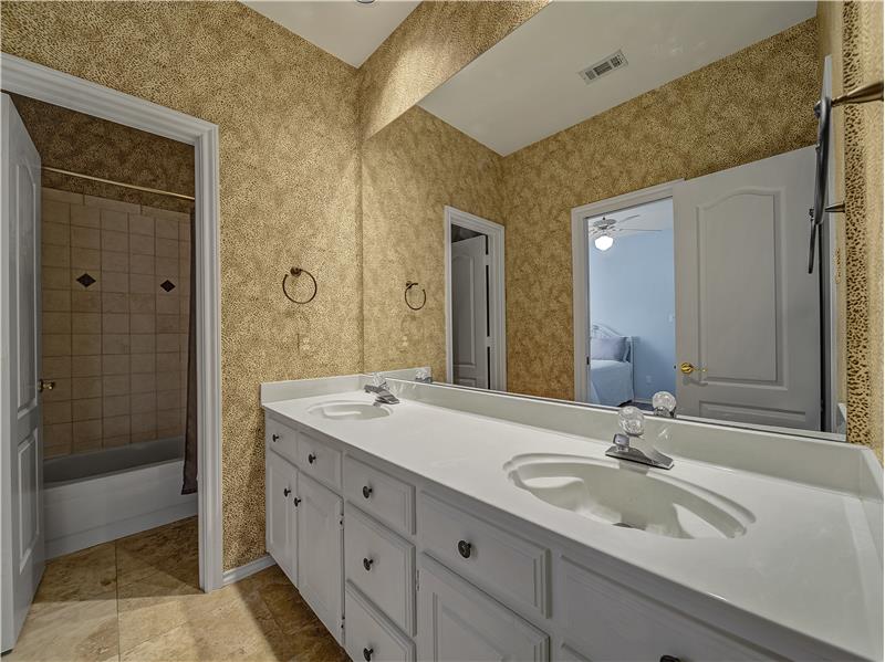 Bathroom with tile patterned floors, dual sinks, and shower / bath combo!