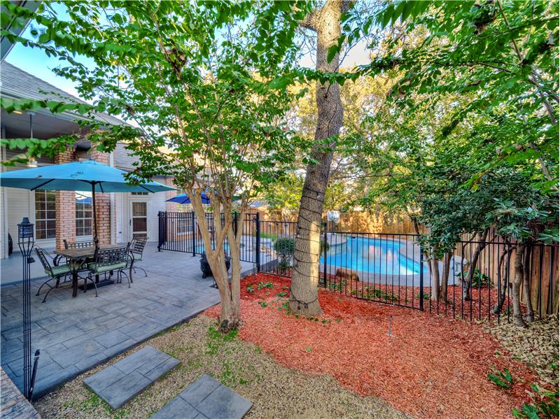 View of the backyard with covered patio and a fenced in pool area!