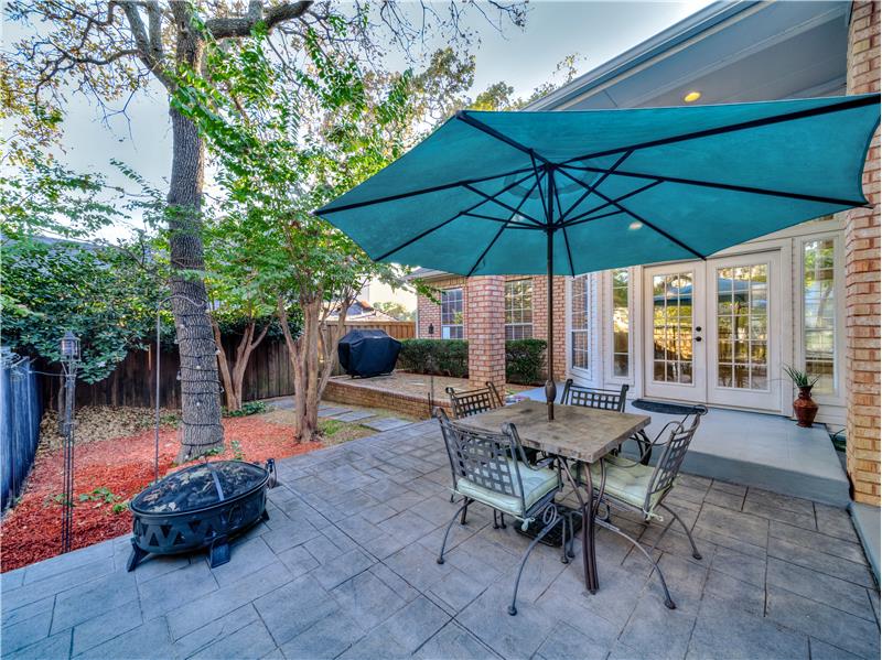 Backyard patio with a fire pit, grilling area, and french doors