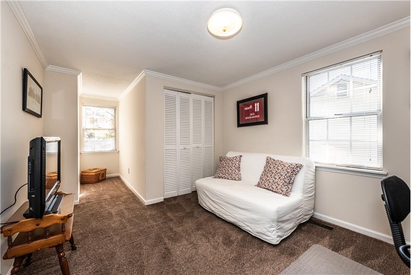 One of two additional bedrooms on second floor with double closet. Neutral decor, crown molding, dormer window.