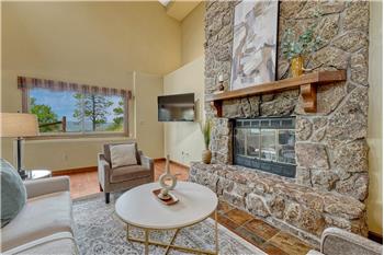 Spacious family room with LVP flooring, vaulted ceilings, & a wood burning fireplace with floor to ceiling stone surround.