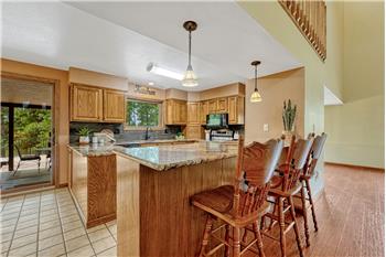 The updated kitchen offers granite countertops, oak cabinetry, pantry, breakfast bar, & full suite of appliances.