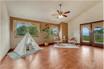 The spacious living room features LVP flooring and French doors to a Trex deck with stunning sunset views.