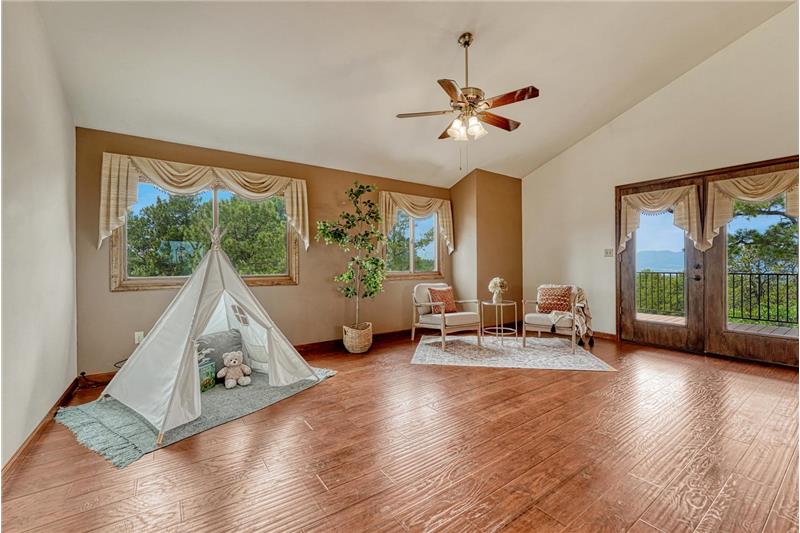 The spacious living room features LVP flooring and French doors to a Trex deck with stunning sunset views.