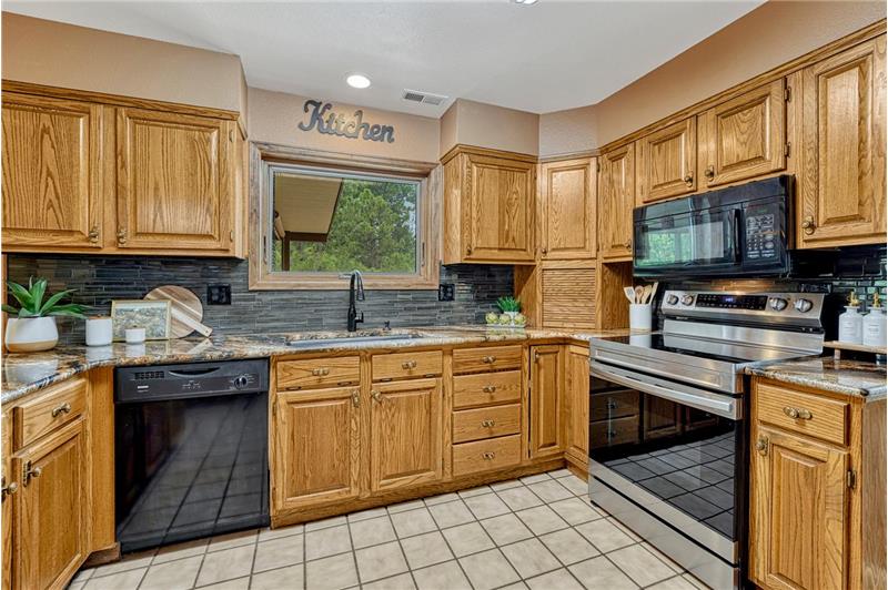 Appliances include a smooth top range oven, overhead microwave, dishwasher, and French door refrigerator.