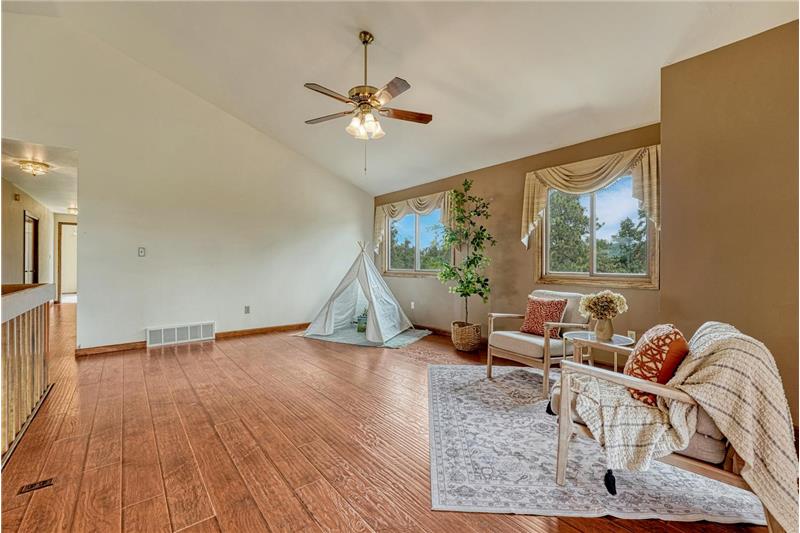 The upper level Living Room provides an additional gathering place with LVP floors and a lighted ceiling.