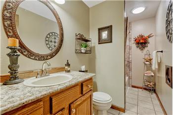 Upper Level Full Bathroom with vanity, mirror, tiled floor, and tiled tub/shower.