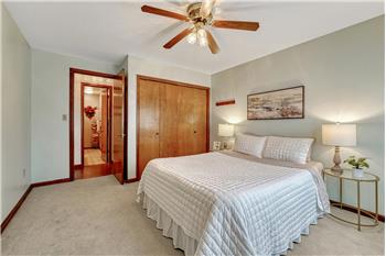 Upper Level Bedroom with carpet and lighted ceiling fan.