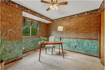 Upper Level Bedroom with neutral carpet and lighted ceiling fan.