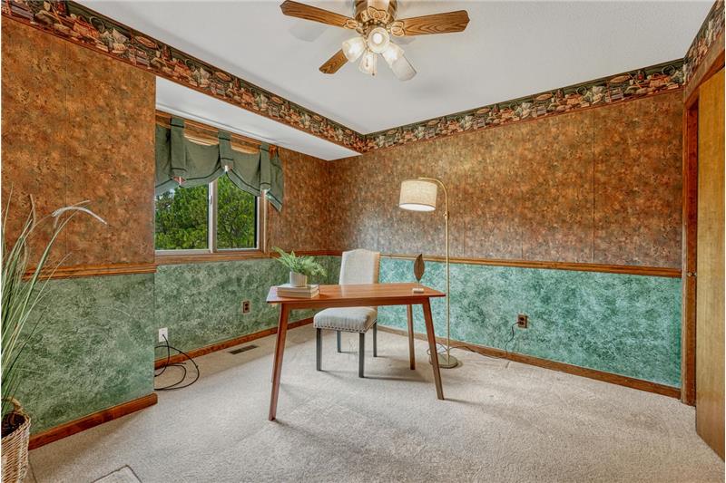 Upper Level Bedroom with neutral carpet and lighted ceiling fan.