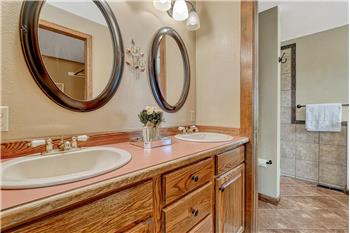 Primary Bathroom with tile floor, dual sink vanity, and mirrors.