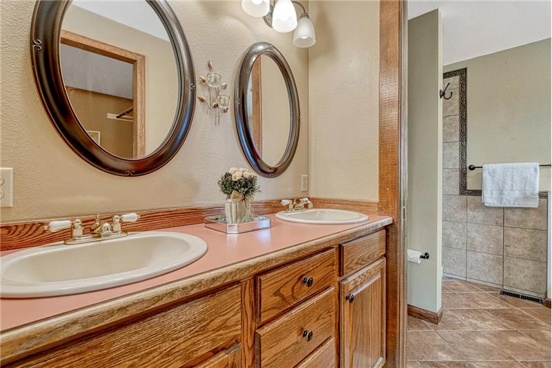 Primary Bathroom with tile floor, dual sink vanity, and mirrors.
