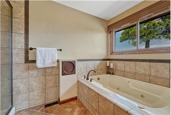 Jetted tub with tile surround in the Primary Bathroom.