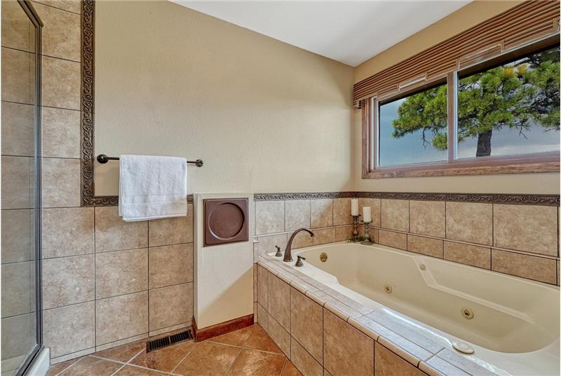 Jetted tub with tile surround in the Primary Bathroom.