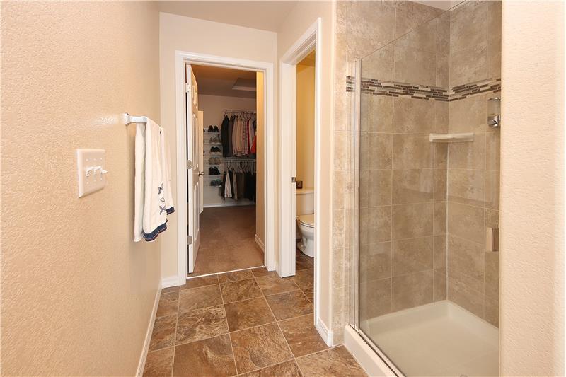 View of tile shower and walk-in closet