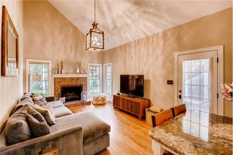 Great room features hardwood floors, brick fireplace, vaulted ceiling.