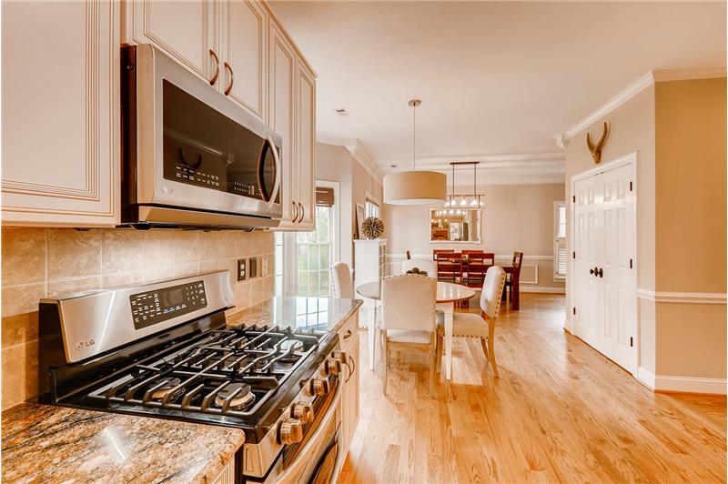 Open sight lines to the breakfast area and dining room. Large pantry to the right features custom shelving/storage.