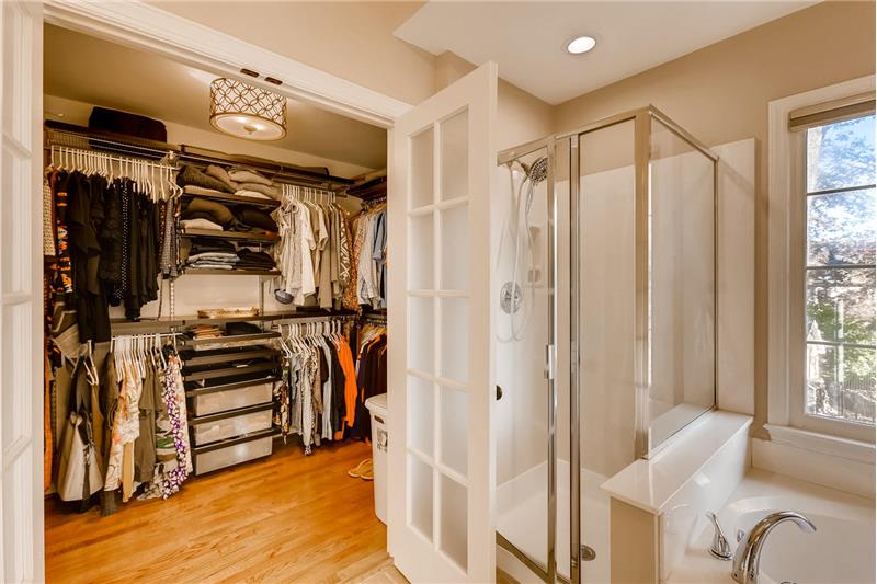 Master walk-in closet Custom shelving provides fantastic storage space. New frosted glass, French doors and light fixture.