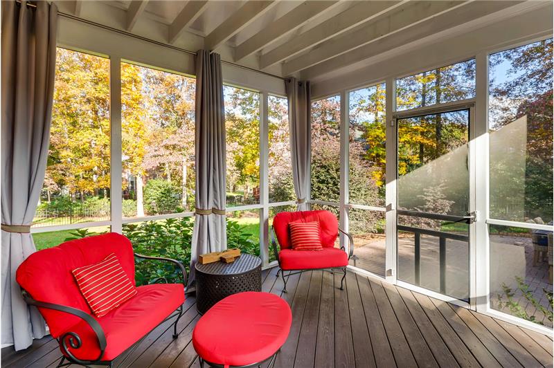 Screened porch is an extension of home's living and entertaining areas overlooking the private, wooded back yard.