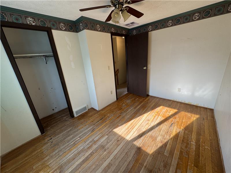 Guest bedroom with hardwood floor.